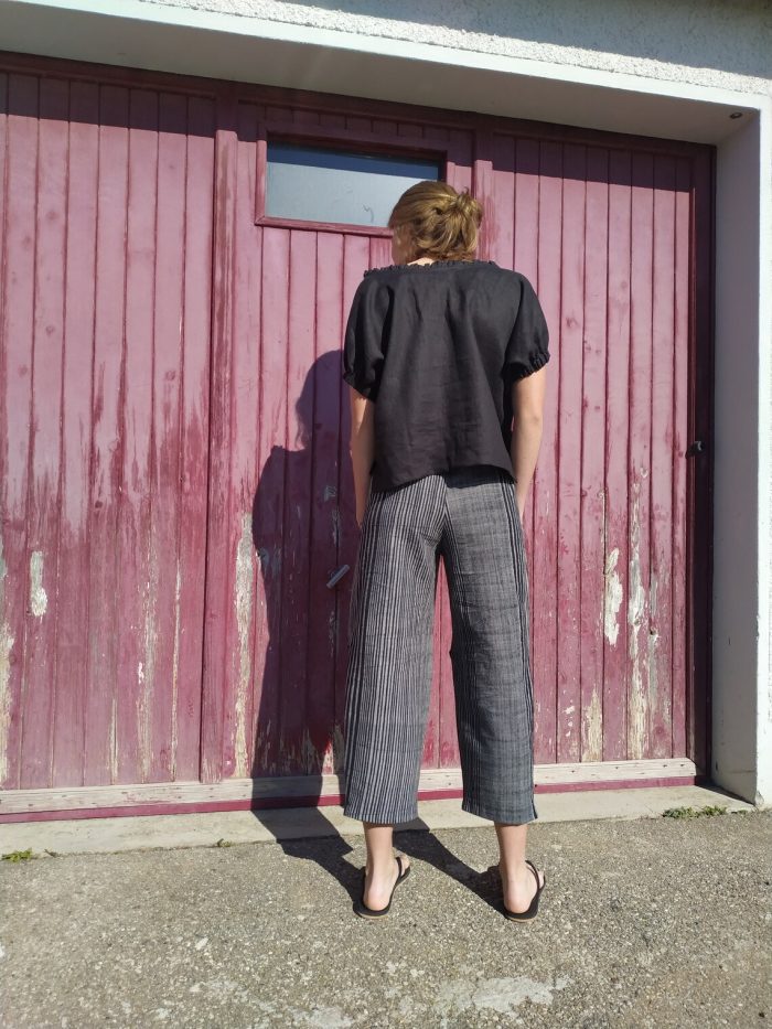 Loose-fitting Mojave trousers featuring an elastic waistband, side pockets, and ankle-length wide legs, shown in lightweight linen.