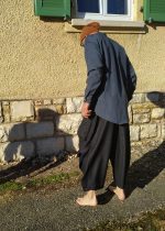 Loose-fitting Mojave trousers featuring an elastic waistband, side pockets, and ankle-length wide legs, shown in lightweight linen.