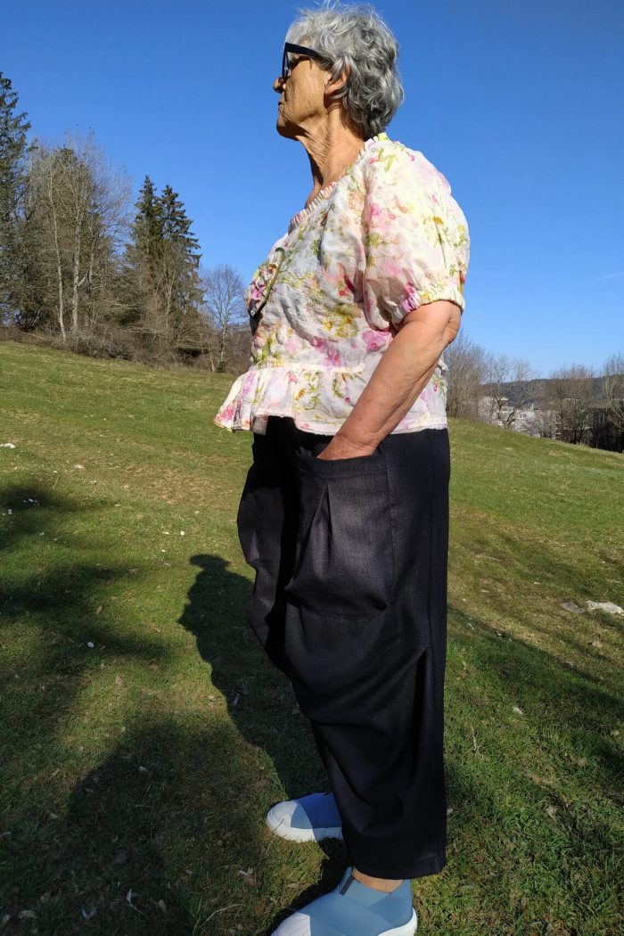 Loose-fitting Mojave trousers featuring an elastic waistband, side pockets, and ankle-length wide legs, shown in lightweight linen.