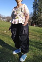 Loose-fitting Mojave trousers featuring an elastic waistband, side pockets, and ankle-length wide legs, shown in lightweight linen.