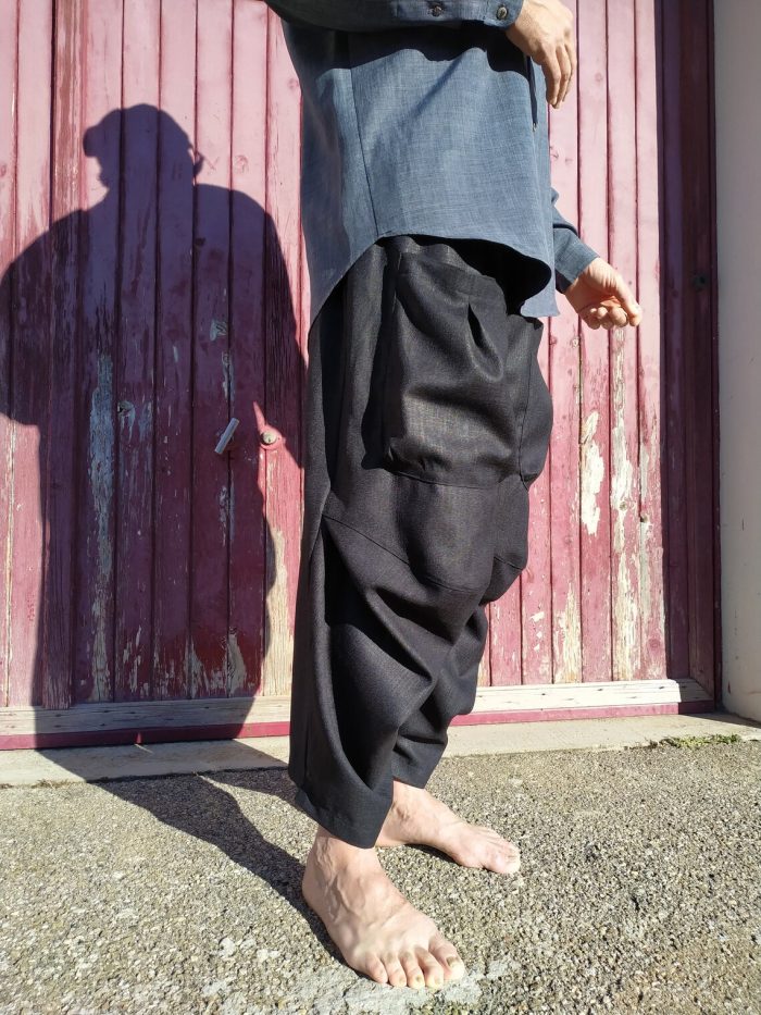 Loose-fitting Mojave trousers featuring an elastic waistband, side pockets, and ankle-length wide legs, shown in lightweight linen.